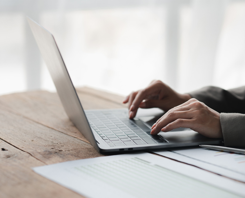 Person typing on laptop keyboard, businessman working on laptop